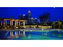 A swimming pool is reflecting the city lights, surrounded by lounge chairs and tables at 270 17Th Nw St # 3606, Atlanta, GA 30363