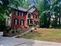 Charming two-story brick home featuring manicured landscaping and steps leading to the entrance at 421 Congress Pkwy, Lawrenceville, GA 30044