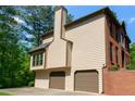 Side view of home featuring a two-car garage and brick wall at 421 Congress Pkwy, Lawrenceville, GA 30044