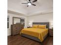 Comfortable main bedroom showcasing a tray ceiling, ceiling fan, and a queen-sized bed with bedside tables at 421 Congress Pkwy, Lawrenceville, GA 30044