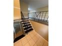 View of interior stairway, featuring black and white tile landing and modern black metal banister at 6399 Boca Grande Blvd, Forest Park, GA 30297