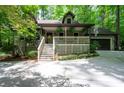 Charming home nestled in the woods with a covered front porch and two-car garage, enhancing curb appeal at 1560 Bubbling Creek Ne Rd, Atlanta, GA 30319