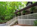 Inviting covered front porch with white railing, steps, and hanging plants creates a welcoming entryway at 1560 Bubbling Creek Ne Rd, Atlanta, GA 30319