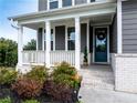 Inviting front porch with white columns and railings, decorated with a wreath and seasonal foliage at 17 Ridgeline Nw Way, Cartersville, GA 30121
