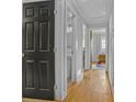Hallway featuring freshly painted walls, sleek doors, and gleaming hardwood floors, leading to various rooms at 233 Dorris Sw Dr, Marietta, GA 30060