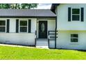 Close up of the home's entryway features a black door with decorative glass insert and black trim at 550 Oglesby Bridge Se Rd, Conyers, GA 30094