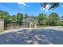 View of the gated entrance, featuring brick pillars, black metal gates, and a wooden fence surrounding the home at 1461 Leach Dr, Lawrenceville, GA 30045
