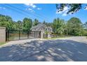 Grand gated entrance featuring a long driveway and mature trees providing privacy and security to the property at 1461 Leach Dr, Lawrenceville, GA 30045