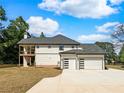 Back exterior of house showcasing a three-car garage and deck overlooking a large backyard at 1461 Leach Dr, Lawrenceville, GA 30045