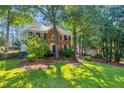 Beautiful two-story brick home with lush green lawn and mature trees at 2151 Hamstead Ct, Suwanee, GA 30024