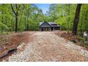 Scenic view of a modern farmhouse with dark gray siding nestled in a lush green wooded area at 1687 Harmony Rd, Temple, GA 30179