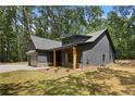 Craftsman home with gray siding, wood porch columns and lush green lawn at 1687 Harmony Rd, Temple, GA 30179