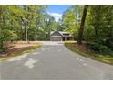 Long driveway leading up to a craftsman home surrounded by mature trees at 1687 Harmony Rd, Temple, GA 30179