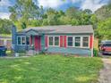 View of the exterior showcasing the blue home with red shutters and a well-maintained lawn at 2404 Shallowford Ter, Atlanta, GA 30341