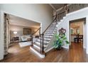 Elegant foyer featuring hardwood floors, staircase with iron railings, and view to the living room at 10830 Carrara Cv, Alpharetta, GA 30022