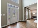 Inviting foyer with decorative glass front door and sidelights, plus hardwood floors at 10830 Carrara Cv, Alpharetta, GA 30022