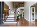 Spacious foyer with hardwood floors, staircase with iron railings, and views to other rooms at 10830 Carrara Cv, Alpharetta, GA 30022