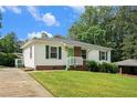 Lovely single-story home showcasing white siding, brick foundation, green shutters, a well-manicured lawn and a concrete driveway at 3650 Croft Nw Pl, Atlanta, GA 30331