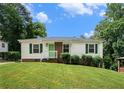 Classic single-story home boasting white siding, a brick foundation, green shutters and a well-maintained front lawn and landscaping at 3650 Croft Nw Pl, Atlanta, GA 30331