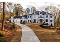 Elegant two-story home featuring a long driveway and manicured landscaping at 5211 Powers Ferry Rd, Sandy Springs, GA 30327