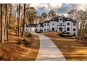 Elegant two-story home featuring a long driveway and manicured landscaping at 5211 Powers Ferry Rd, Sandy Springs, GA 30327