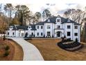 Elegant two-story home featuring a long driveway and manicured landscaping at 5211 Powers Ferry Rd, Sandy Springs, GA 30327