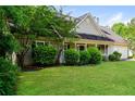 Traditional home featuring a covered front porch, manicured lawn, and mature trees at 85 Chestnut Dr, Covington, GA 30016