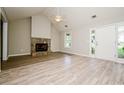 Bright living room featuring a stone fireplace, vaulted ceilings, and wood-look floors, creating a cozy atmosphere at 85 Chestnut Dr, Covington, GA 30016