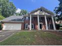 Traditional brick home featuring a spacious two-car garage and stately white columns at the entryway at 2000 Brickton Sta, Buford, GA 30518