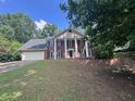 Charming two-story brick home features a large front yard, white columns and a two-car garage at 2000 Brickton Sta, Buford, GA 30518