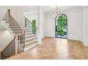 Elegant foyer with herringbone wood floors, staircase, and a window letting in natural light at 3379 Rennes Ne Dr, Brookhaven, GA 30319