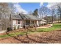 Well-maintained home with a welcoming front porch, complemented by green lawn and mature trees, creating a serene setting at 4150 E Chapel Hill Rd, Douglasville, GA 30135