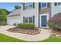 Charming home featuring stone accents, manicured lawn, and an attached two-car garage at 1070 Evergreen Oak Way, Dacula, GA 30019