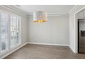 Dining room with hardwood floors, natural light, and modern light fixture adjacent to the kitchen at 2058 Drogheda Ln, Marietta, GA 30066