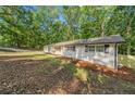 Exterior view of property with painted white brick and lush tree coverage at 5155 Oakdale Ct, Douglasville, GA 30135