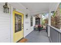 Inviting front porch with comfortable seating, a yellow front door, and stylish decor at 571 Morgan Ne St, Atlanta, GA 30308