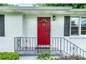 Close up of the home's front porch with a charming red door, black shutters and a heart-patterned railing at 218 Woodview Se Ln, Smyrna, GA 30082