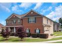 Charming two-story home with brick and siding exterior, green shutters, and well-maintained lawn at 1104 Stepping Stone Ln, Conyers, GA 30012