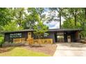 Charming home featuring a black brick exterior, wooden details, and a well-manicured front yard at 2382 Whites Mill Ln, Decatur, GA 30032