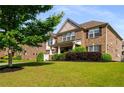 Beautifully landscaped front yard showcasing a two-story brick home with a covered porch at 1520 Gallant Fox Ln, Suwanee, GA 30024