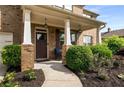 Inviting covered porch with stylish columns and manicured landscaping at 1520 Gallant Fox Ln, Suwanee, GA 30024