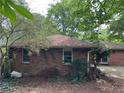 Rear exterior view of a brick home with a backyard and mature trees at 2226 Medfield Ne Trl, Atlanta, GA 30345