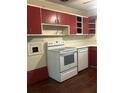 Classic kitchen with white countertops, red cabinets, and white appliances at 2226 Medfield Ne Trl, Atlanta, GA 30345