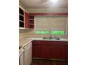 Functional kitchen features stainless steel sink, and traditional red cabinets at 2226 Medfield Ne Trl, Atlanta, GA 30345