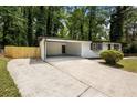 Spacious carport with a concrete floor, white brick walls, and a rear door for convenience at 4720 Shoshonee Trl, College Park, GA 30349