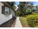 View of side yard with landscaping and walkway leading to the front entrance of the house at 4720 Shoshonee Trl, College Park, GA 30349