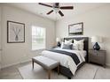 This bedroom has soft carpet, neutral tones, a ceiling fan, and window bringing in natural light at 131 Prominence Ct, Canton, GA 30114