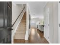 Inviting entryway featuring hardwood floors, staircase, and views into the living area at 208 Magnolia Leaf Dr, Woodstock, GA 30188
