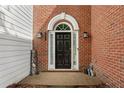 Elegant front door with decorative trim and sidelights, set in a brick facade at 208 Magnolia Leaf Dr, Woodstock, GA 30188