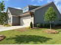 A charming house is seen from the side with a well-kept lawn and beautiful landscaping, trees, and concrete driveway at 208 Saratoga Dr, Acworth, GA 30102